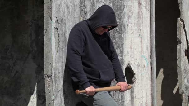 Homem com um taco de beisebol perto da parede
  - Filmagem, Vídeo