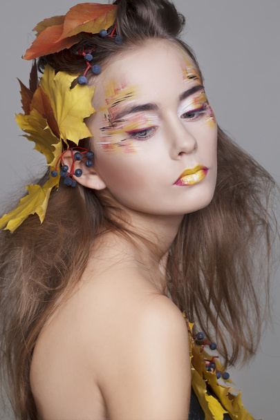 Beautiful girl with autumn make up and leaves on head - Fotó, kép