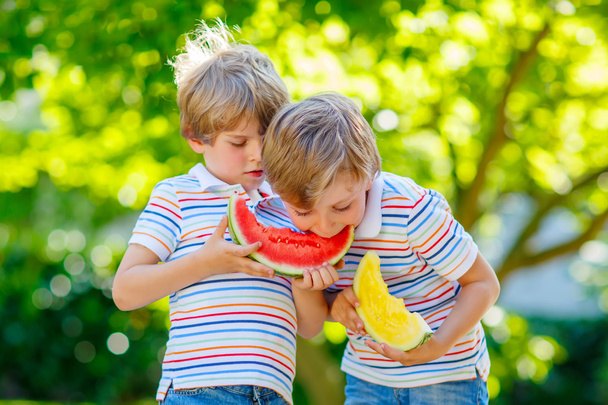 Due piccoli bambini in età prescolare che mangiano anguria in estate
 - Foto, immagini