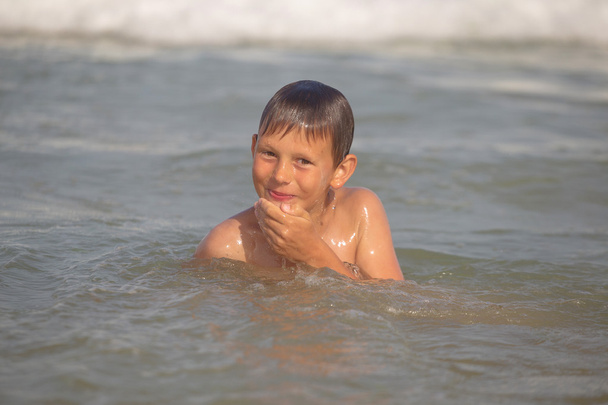 Junge tobt im Meer mit Spritzern und Wellen - Foto, Bild