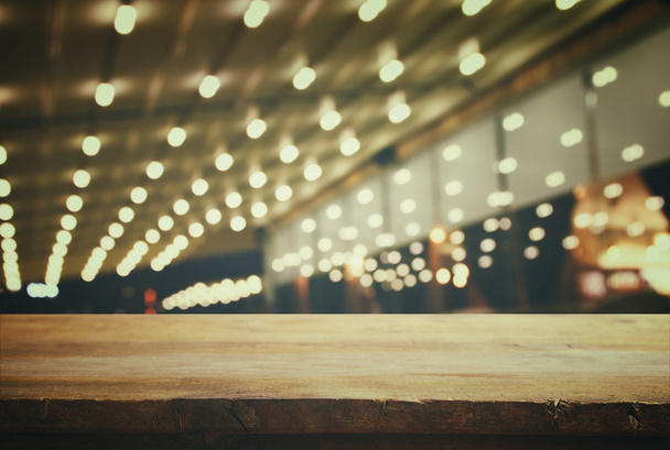 wooden table in front of abstract blurred resturant lights - 写真・画像