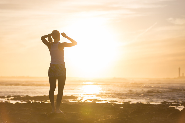 Woman on sandy beach watching sunset. - Photo, Image