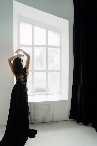 Ατομικότητα. Στοχαστικό κομψή κυρία σε μαύρο χορό φόρεμα βράδυ. Retouched φωτογραφία στούντιο. - Φωτογραφία, εικόνα