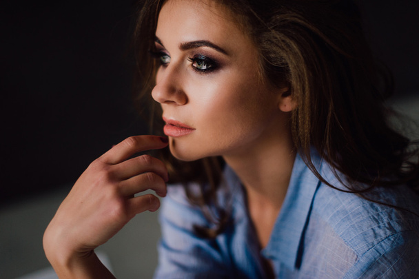 Portrait de jeune femme positive sexy posant en studio à la lumière naturelle, portant une chemise bleue, a un bon ajustement et en bonne santé. Studio retouché
. - Photo, image