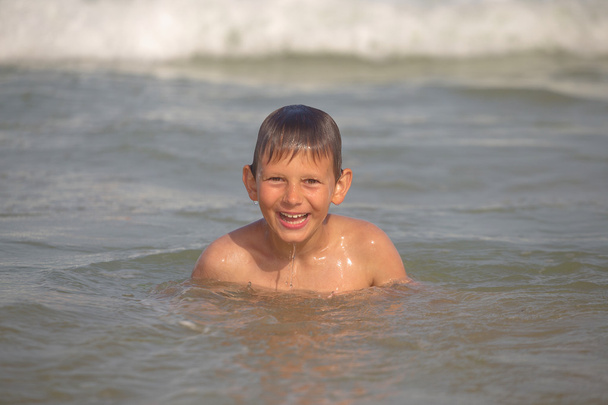 ευθυμίες αγόρι στη θάλασσα με πιτσιλιές και κύματα - Φωτογραφία, εικόνα