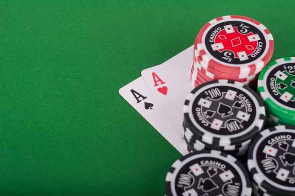 pair of aces, red and black cassino chips on green table - Zdjęcie, obraz