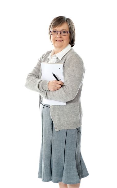 Senior woman holding spiral notepad and pen - Foto, imagen