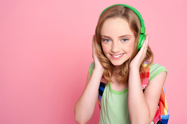 Pretty teenager enjoying music on headphones - Foto, Bild
