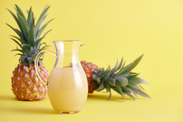 Lasi kannu tuoretta ananasmehua keltaisella
 - Valokuva, kuva