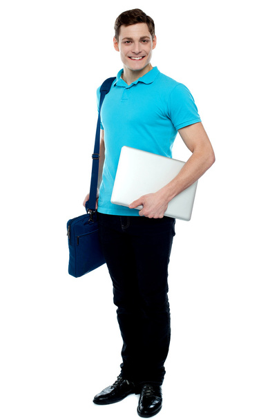 Cheerful man carrying laptop, off to work - Фото, изображение