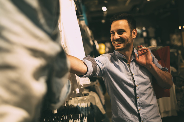 Handsome man shopping for clothes - Fotografie, Obrázek