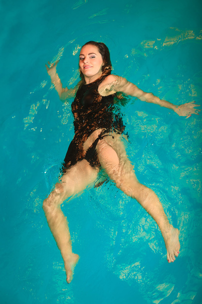 Woman floating relaxing in swimming pool water. - Фото, зображення