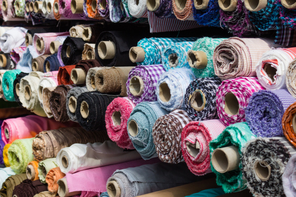 fabric rolls at market stall - textile industry background - Photo, Image
