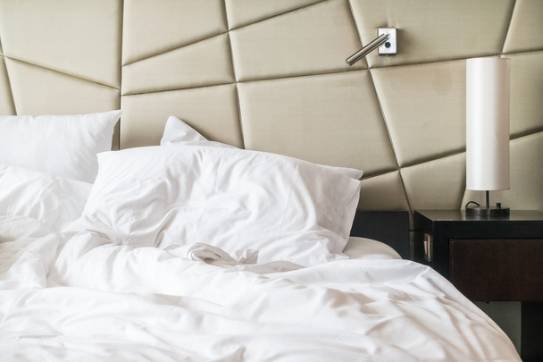 lit froissé avec oreiller salissant blanc
  - Photo, image