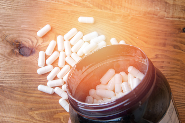 Kreatiini tabletit puinen pöytä
 - Valokuva, kuva
