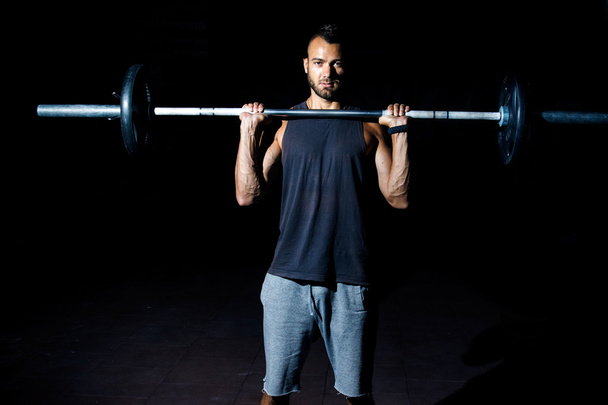 Фитнес-человек готовится к упражнениям с штангой в тренажерном зале
 - Фото, изображение
