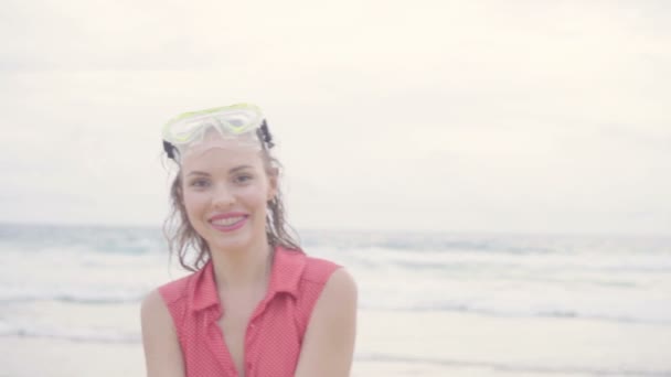 Close-up de bela mulher feliz loira vestindo camisa de colarinho vermelho e máscara de natação sorrindo e posando em um belo dia de verão na praia sobre fundo do mar e céu- vídeo em câmera lenta
 - Filmagem, Vídeo