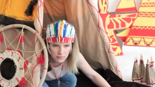 Young blonde girl in native American Indian costume crawling from wigwam - Footage, Video