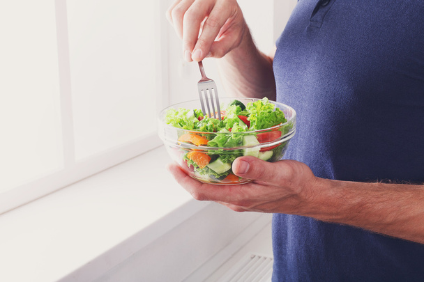 Unrecognizable man has healthy lunch, eating diet vegetable salad - Photo, Image