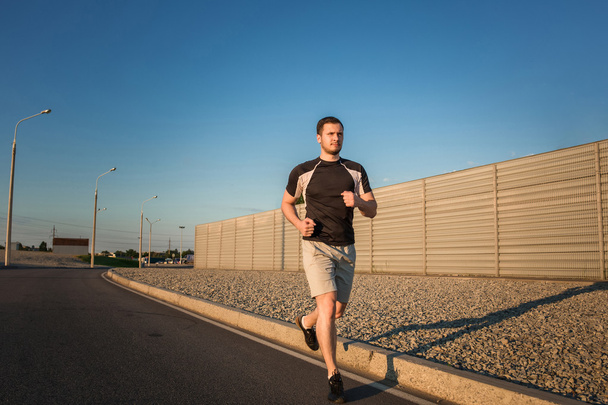 Ganzkörperporträt eines athletischen Mannes beim Laufen - Foto, Bild