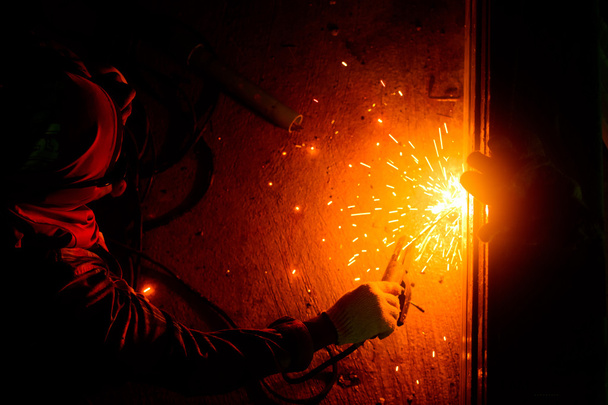 Los trabajadores del metal utilizan mano de obra, Soldador calificado, Trabajadores de fábrica haciendo OT. Soldador está soldando el acero en la fábrica. - Foto, imagen