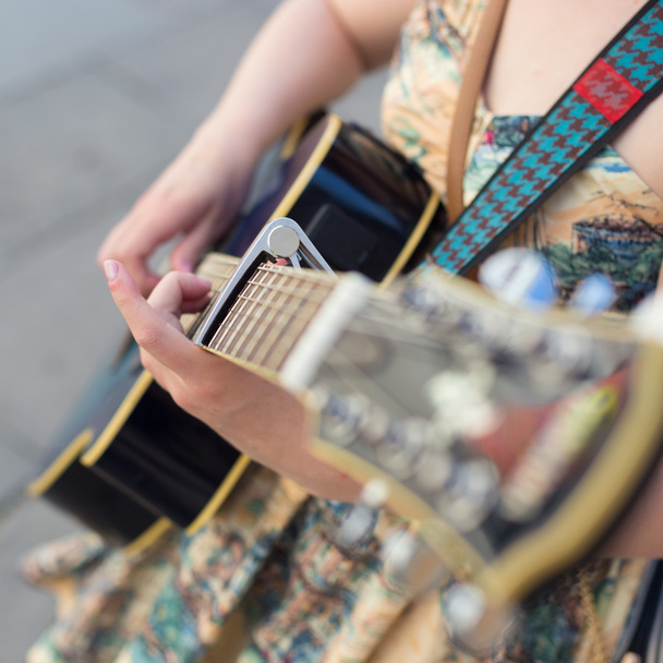 Female street musician playing guitar. - Photo, Image