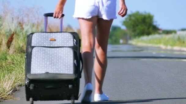 Au ralenti. Été chaud et femme sexy jambes fines avec valise sur la route
. - Séquence, vidéo