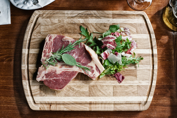 Raw meat with vegetables in the kitchen - Foto, afbeelding