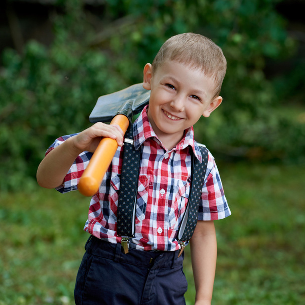 funny boy with shovel in garden - Foto, afbeelding