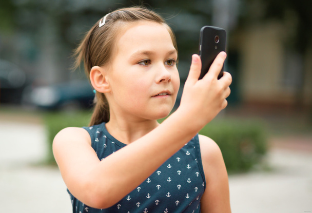 Girl is shooting photo using smartphone - Photo, Image