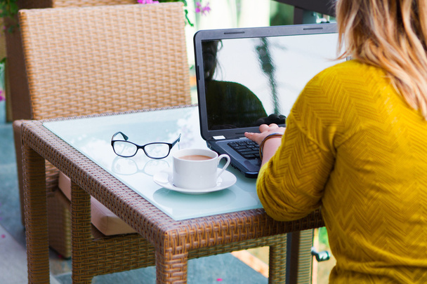 Mãos de mulher no teclado do seu computador portátil. Feminino trabalhando em laptop em um café de rua, tema de negócios
  - Foto, Imagem