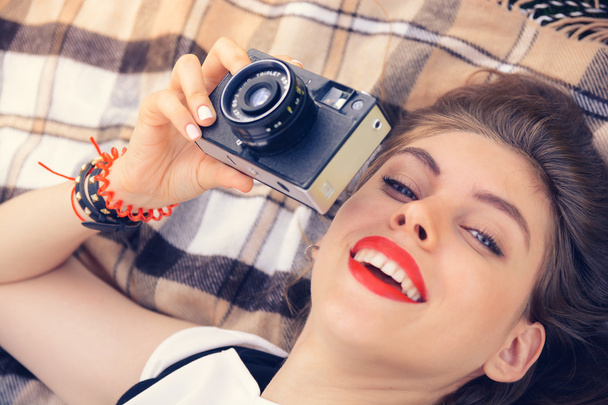 young happy woman laying with old film camera - Foto, afbeelding
