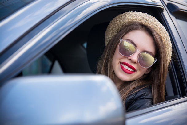 happy woman in summer hat and sunglasses driving car outdoors - Zdjęcie, obraz