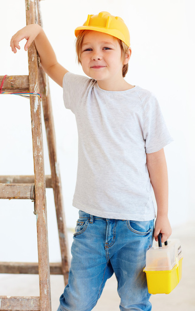 cute young boy, foreman standing near the ladder - Fotoğraf, Görsel