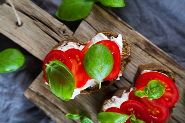 Bruschetta with cream cheese cherry tomatoes and basil - Фото, зображення