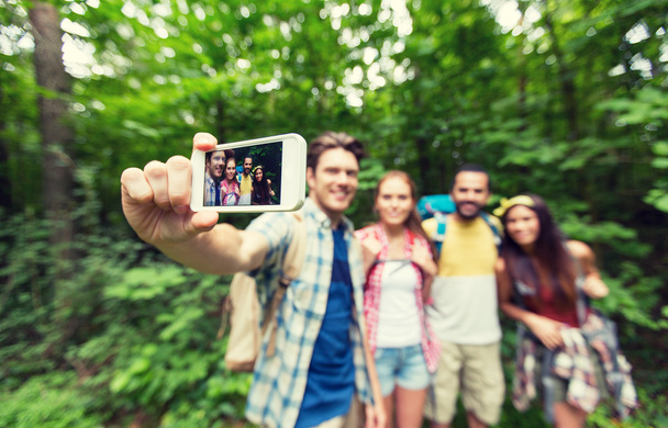 friends with backpacks taking selfie by smartphone - Valokuva, kuva