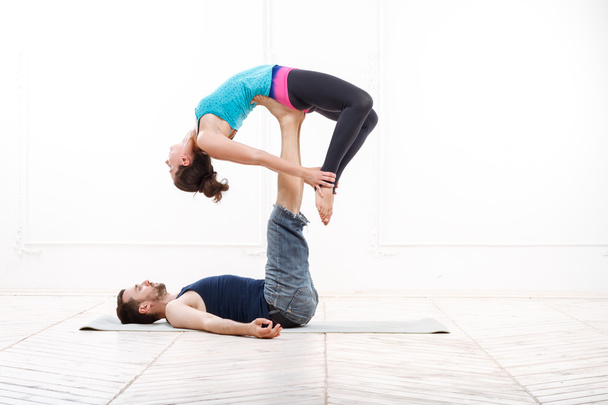 Beautiful Young Couple Practicing Acro-Yoga - Foto, immagini