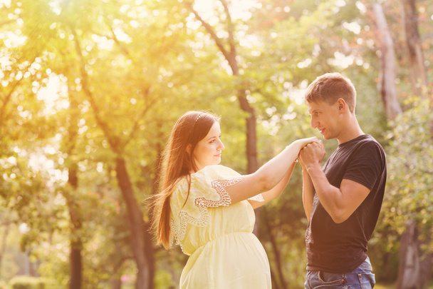 the young beautiful pregnant woman with the husband in park in summer day - Photo, Image