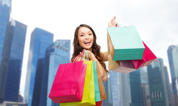 happy woman with shopping bags over singapore city - Φωτογραφία, εικόνα