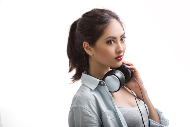 Young beautiful woman listening to music with big headphones isolated white background - Zdjęcie, obraz
