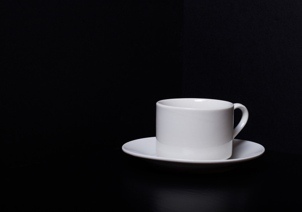 White cup and saucer on a black background - Foto, Imagem