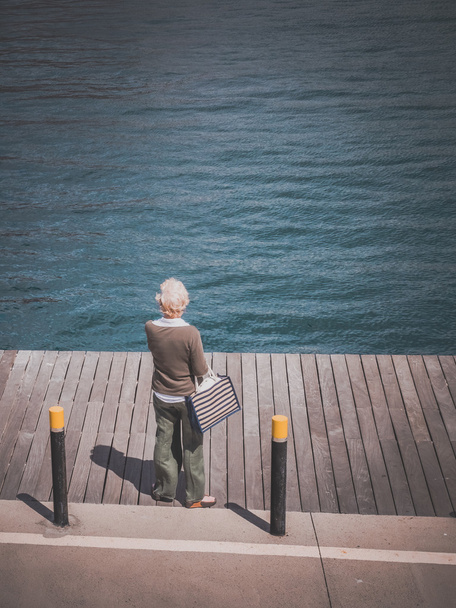 Old woman looking at sea - Фото, зображення