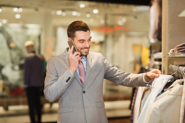 happy man calling on smartphone at clothing store - Фото, зображення