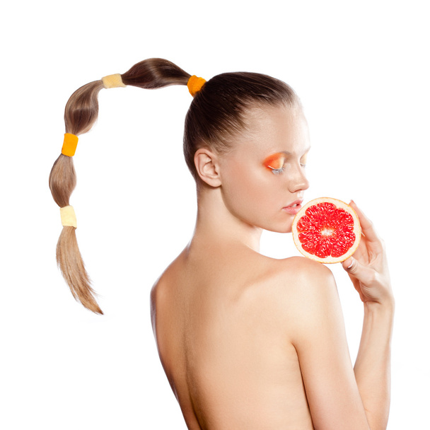 Beautiful woman with grapefruit and creative hairstyle - Foto, Imagem