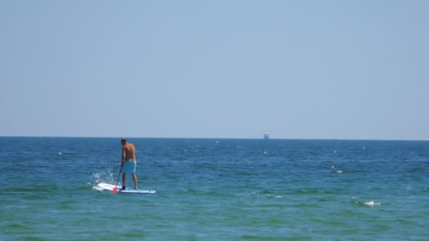 Evezés-férfi felállni a tengeren van, nyáron - Felvétel, videó