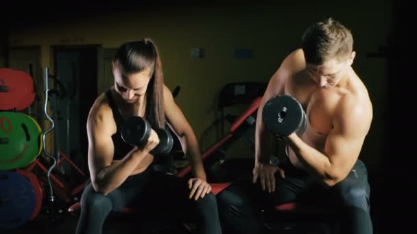 Férfi és nő dolgozik a karját, az edzőteremben. - Felvétel, videó