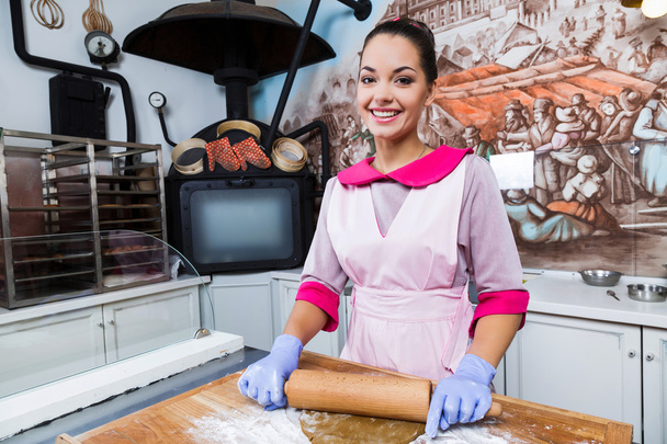 Young smiling woman kneads the dough - Photo, Image