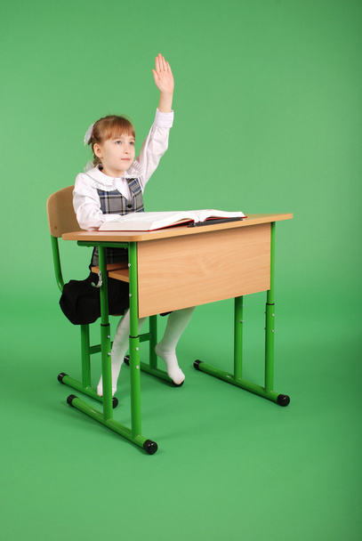 Fille dans un uniforme scolaire assis à un bureau
 - Photo, image