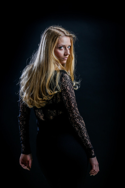 blonde girl on a black background in a dark guipure dress - Foto, Imagem