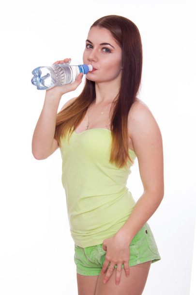 Female fitness model holding a water bottle - Фото, изображение